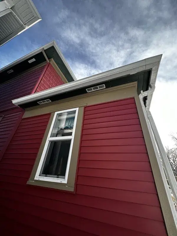 Exterior house painting by iPaint Painting — red siding with white trim in Edmonton